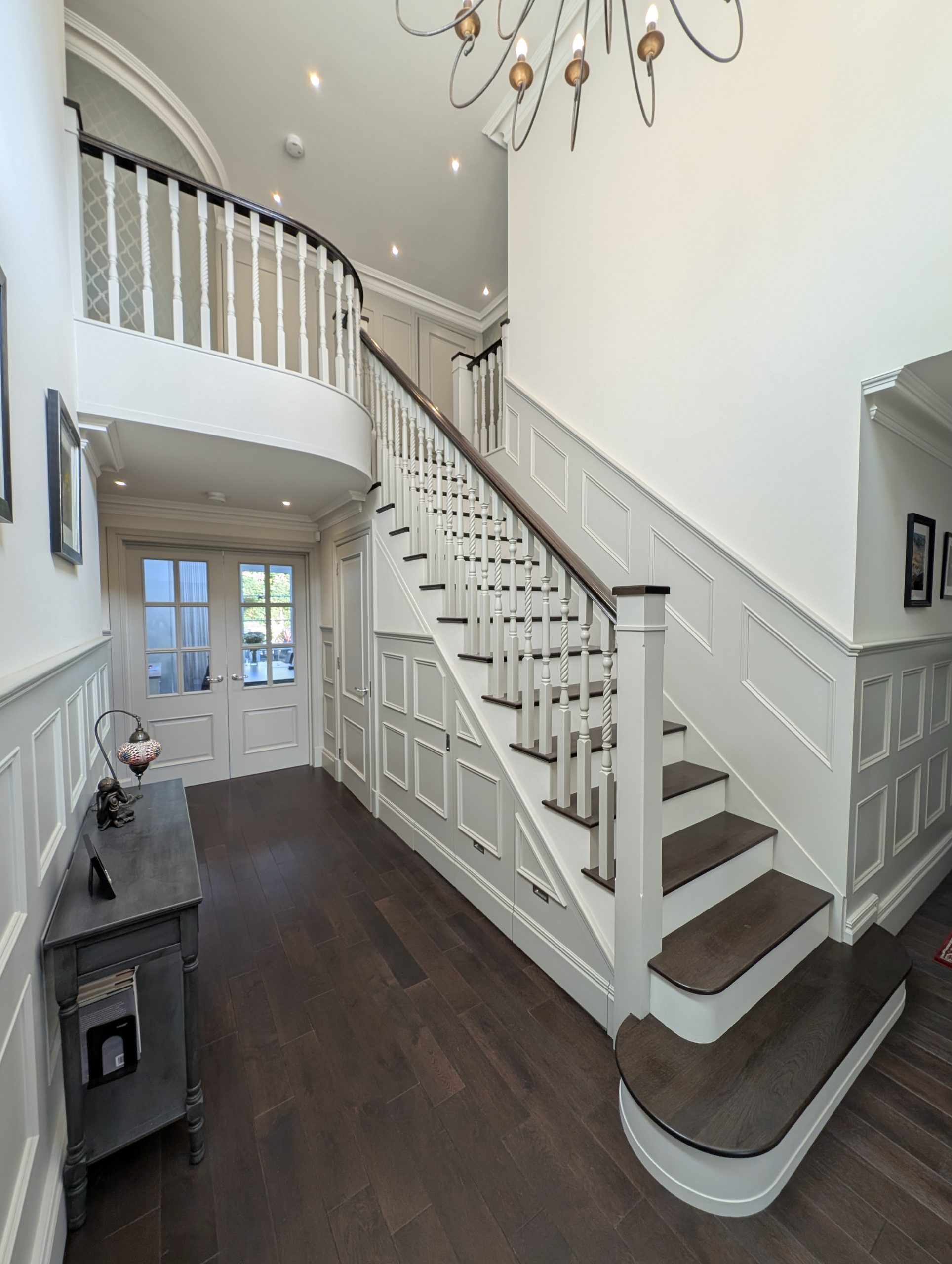 Staircase and hallway with white balustrade and dark wood flooring, done by a decorator in Poole